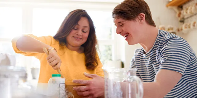 Person with disabilities helping caregiver bake