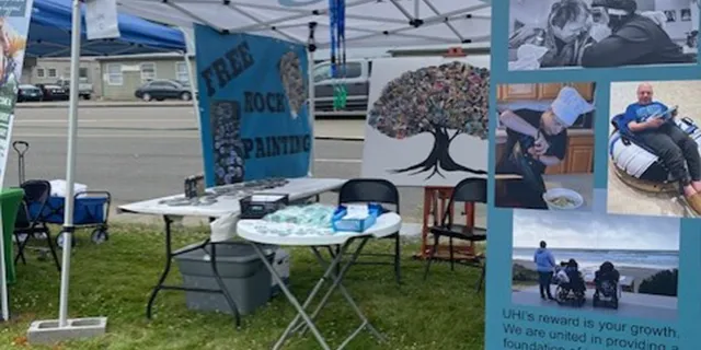 UHI event banner up and a tent with a sign that says Free Rock Painting